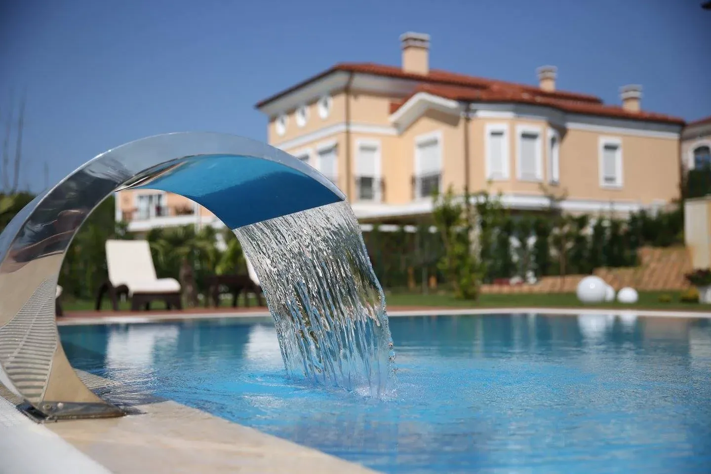 Villa bahçesindeki havuza su perdesi döken paslanmaz Kobra şelale